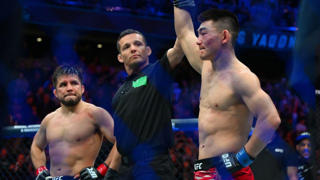 ; Song Yadong (blue gloves) celebrates after defeating Henry Cejudo (red gloves) in the bantamweight bout during UFC Fight Night at Climate Pledge Arena.