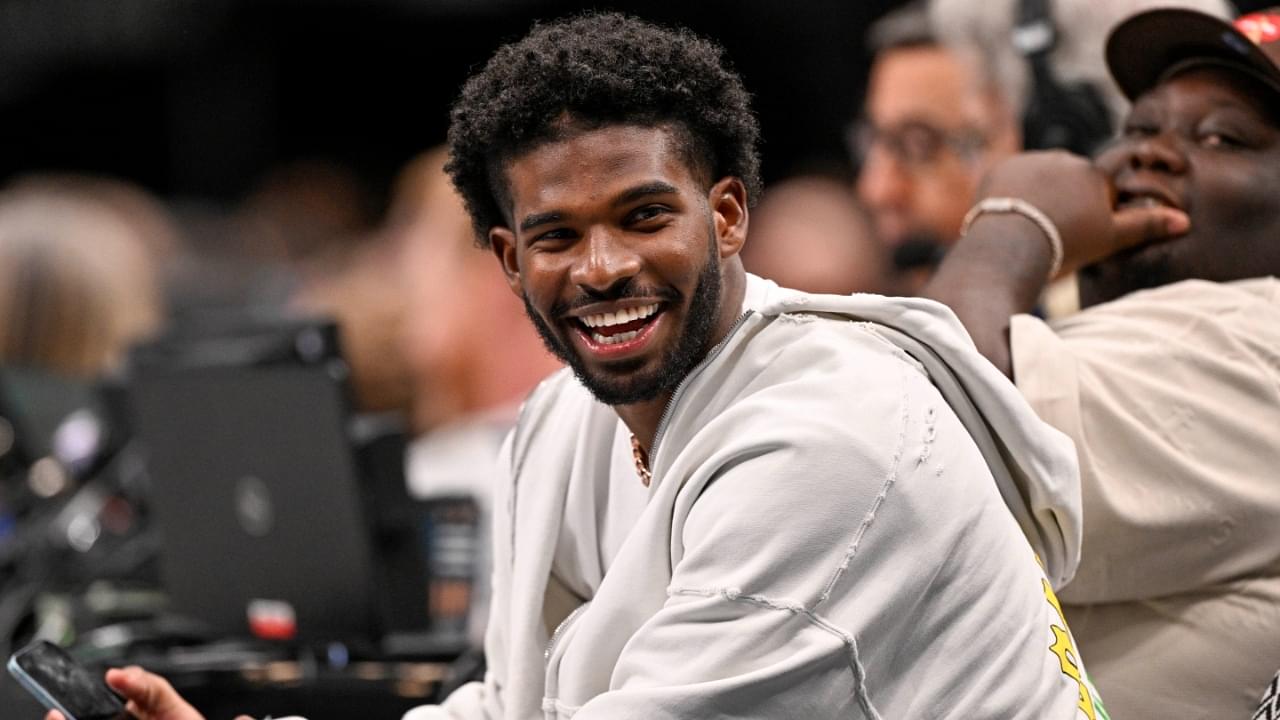 Jan 14, 2025; Dallas, Texas, USA; Colorado Buffaloes quarterback Shedeur Sanders laughs as he watches the game between the Dallas Mavericks and the Denver Nuggets during the second half at the American Airlines Center.