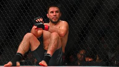 Henry Cejudo (red gloves) sits down after being poked in the eye by Song Yadong (blue gloves) in the bantamweight bout during UFC Fight Night at Climate Pledge Arena.