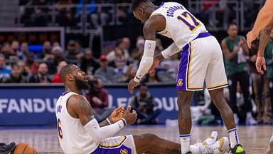 Los Angeles Lakers guard Dennis Schroder (17) helps up teammate Los Angeles Lakers forward LeBron James (6) during the second half of a game against the Detroit Pistons at Little Caesars Arena.