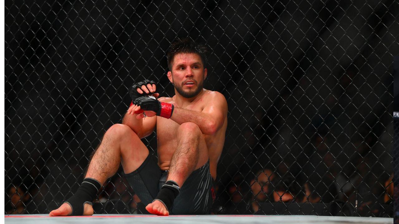 Henry Cejudo (red gloves) sits down after being poked in the eye by Song Yadong (blue gloves) in the bantamweight bout during UFC Fight Night at Climate Pledge Arena.