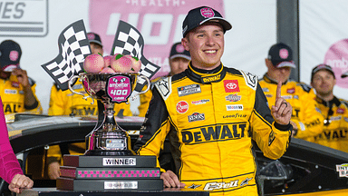 Feb 23, 2025; Hampton, Georgia, USA; Christopher Bell (20) poses with his trophy in Victory Lane after claiming a victory at Atlanta Motor Speedway. Mandatory Credit: Jason Allen-Imagn Images