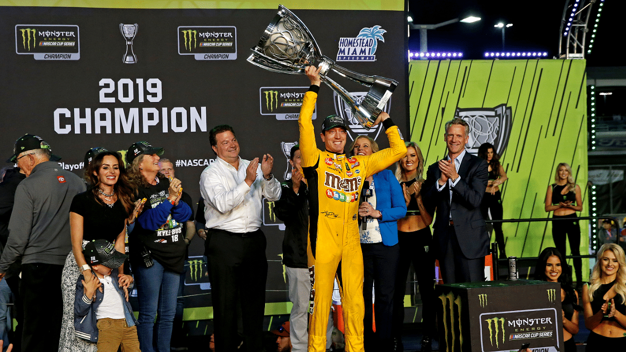 Nov 17, 2019; Homestead, FL, USA; NASCAR Cup Series driver Kyle Busch (18) celebrates winning the NASCAR Cup Series Championship after the Ford EcoBoost 400 at Homestead-Miami Speedway. Mandatory Credit: Peter Casey-Imagn Images