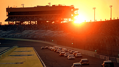 The sun sets as the field goes down the front stretch during the Ford Ecoboost 400 at Homestead-Miami Speedway.