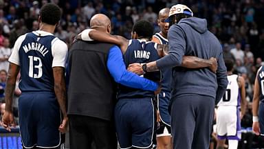 Dallas Mavericks guard Kyrie Irving (11) is helped off the court by forward Naji Marshall (13) and forward Anthony Davis (3) during the second quarter against the Sacramento Kings at the American Airlines Center