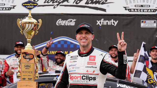 Apr 6, 2025; Darlington, South Carolina, USA; NASCAR Cup Series driver Denny Hamlin (11) and his crew celebrate the win during the Goodyear 400 at Darlington Raceway. Mandatory Credit: Jim Dedmon-Imagn Images