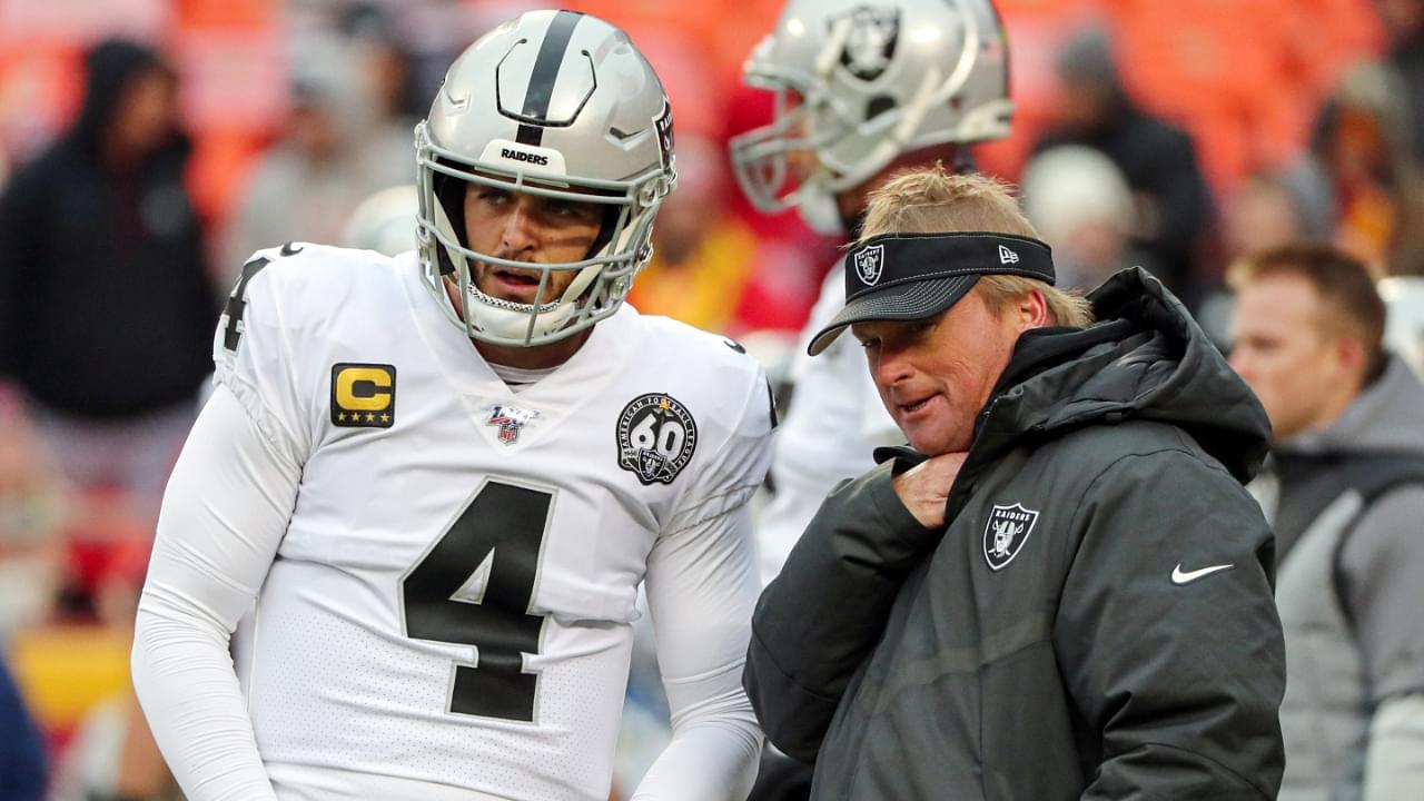 Oakland Raiders head coach Jon Gruden talks with quarterback Derek Carr (4) before the game against the Kansas City Chiefs at Arrowhead Stadium.