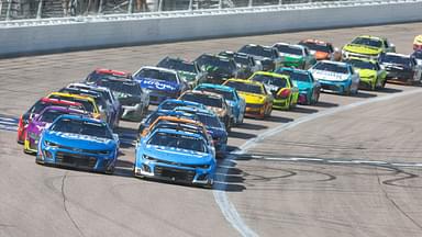 NASCAR Cup Series drivers Chase Elliott (9) and Kyle Larson (5) lead the pack during a restart at the AdventHealth 400 at Kansas Speedway.