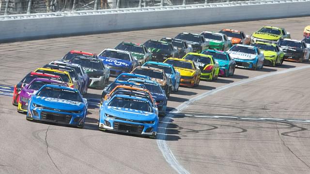 NASCAR Cup Series drivers Chase Elliott (9) and Kyle Larson (5) lead the pack during a restart at the AdventHealth 400 at Kansas Speedway.