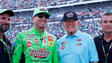 NASCAR Cup Series driver Kyle Busch (left center) and Joe Gibbs Racing owner Joe Gibbs (right center) in pit road prior to the start of the Coke Zero 400 at Daytona International Speedway.