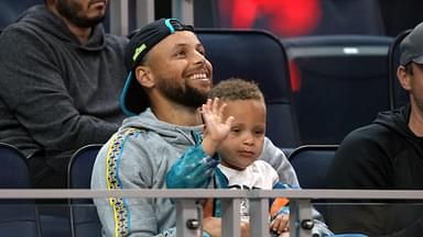 Golden State Warriors guard Stephen Curry (30) sits in the stands with son Canon during the second quarter against the Sacramento Kings at the California Summer League at Chase Center.