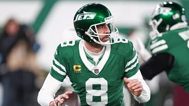 New York Jets quarterback Aaron Rodgers (8) rolls out during the first half against the Miami Dolphins at MetLife Stadium.
