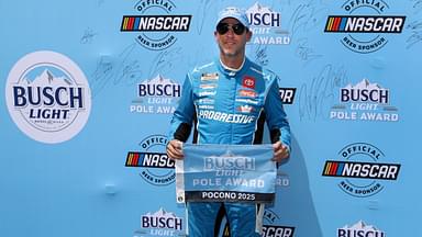 NASCAR Cup Series driver Denny Hamlin stands with the Busch Light Pole Award after winning the pole for The Great American Getaway 400 at Pocono Raceway.