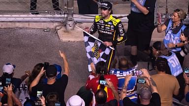 NASCAR Cup Series driver Ryan Blaney (12) heads into the stands to give away the checkered flag after winning the Cracker Barrel 400 NASCAR Cup Series race at Nashville Superspeedway in Lebanon, Tenn., Sunday, June 1, 2025.