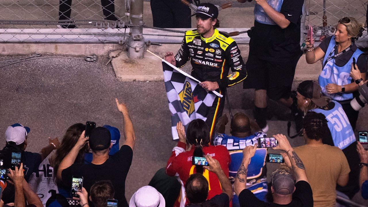 NASCAR Cup Series driver Ryan Blaney (12) heads into the stands to give away the checkered flag after winning the Cracker Barrel 400 NASCAR Cup Series race at Nashville Superspeedway in Lebanon, Tenn., Sunday, June 1, 2025.