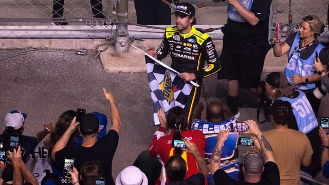 NASCAR Cup Series driver Ryan Blaney (12) heads into the stands to give away the checkered flag after winning the Cracker Barrel 400 NASCAR Cup Series race at Nashville Superspeedway in Lebanon, Tenn., Sunday, June 1, 2025.