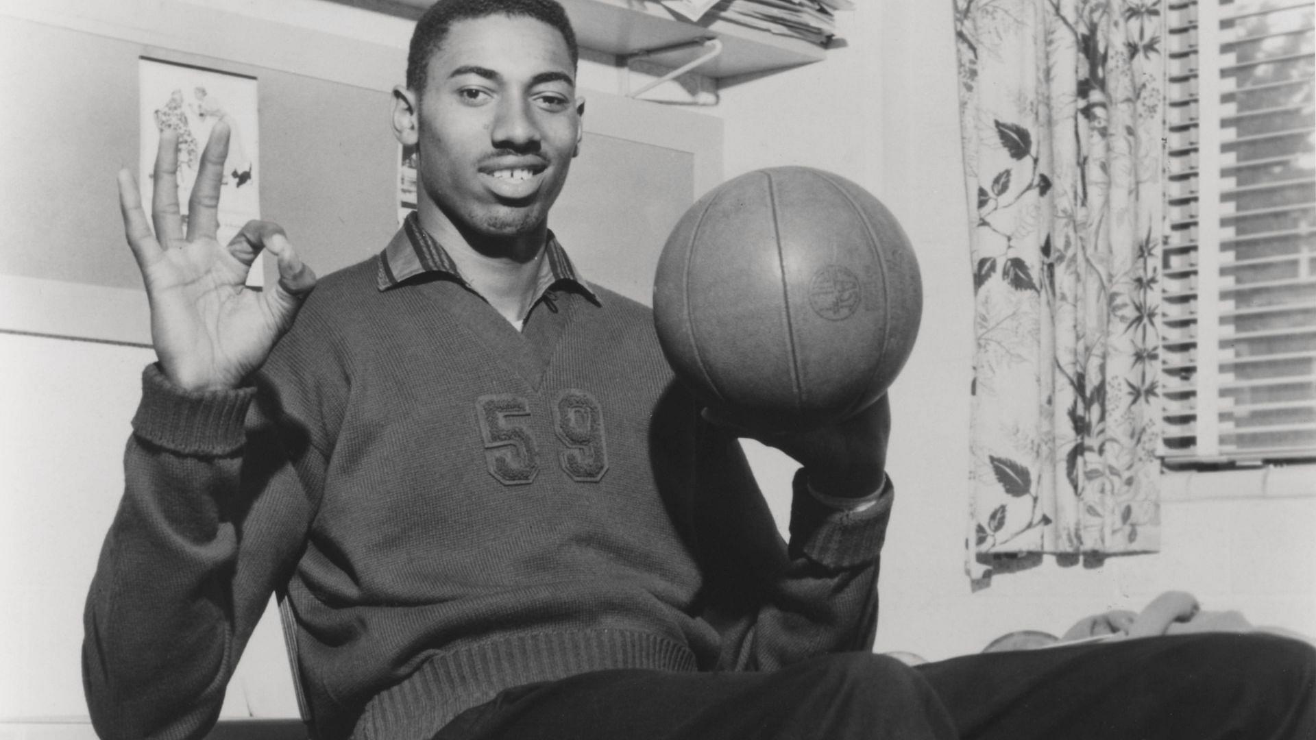 Vintage 1960 s capture of Wilt Chamberlain smiling while spinning a basketball
