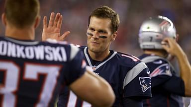 New England Patriots quarterback Tom Brady (12) and tight end Rob Gronkowski (87) react from the sideline after a touchdown against the Green Bay Packers during the first half in a preseason NFL football game at Gillette Stadium.