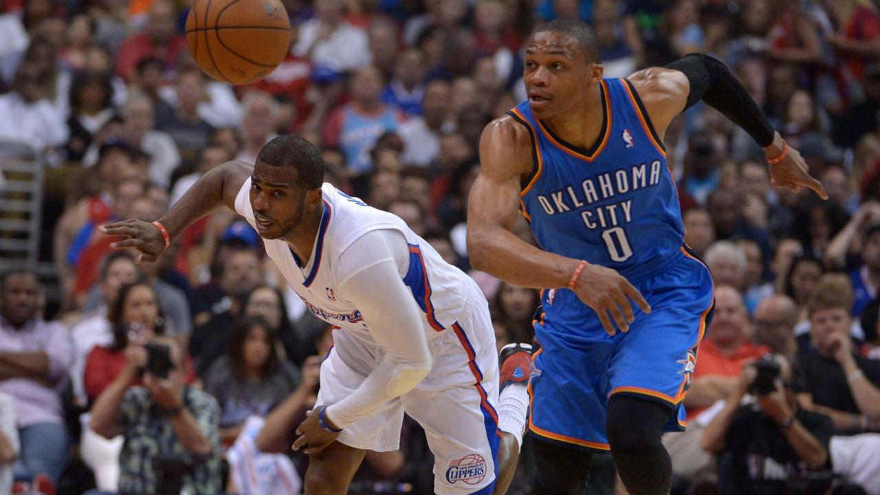 Los Angeles Clippers guard Chris Paul (3) and Oklahoma City Thunder guard Russell Westbrook (0) race toward the ball in game four of the second round of the 2014 NBA Playoffs at Staples Center.