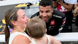 NASCAR Cup Series driver Bubba Wallace (23) embraces his wife, Amanda Carter, and child, Becks, on Sunday, July 27, 2025, after winning the Brickyard 400 at Indianapolis Motor Speedway.