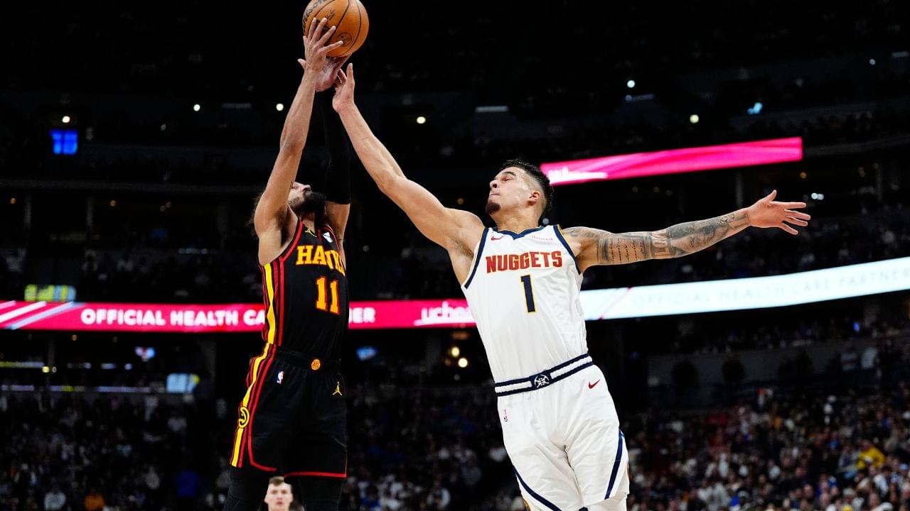 Atlanta Hawks guard Trae Young (11) and Denver Nuggets forward Michael Porter Jr. (1) reach for the ball in the second quarter at Ball Arena.