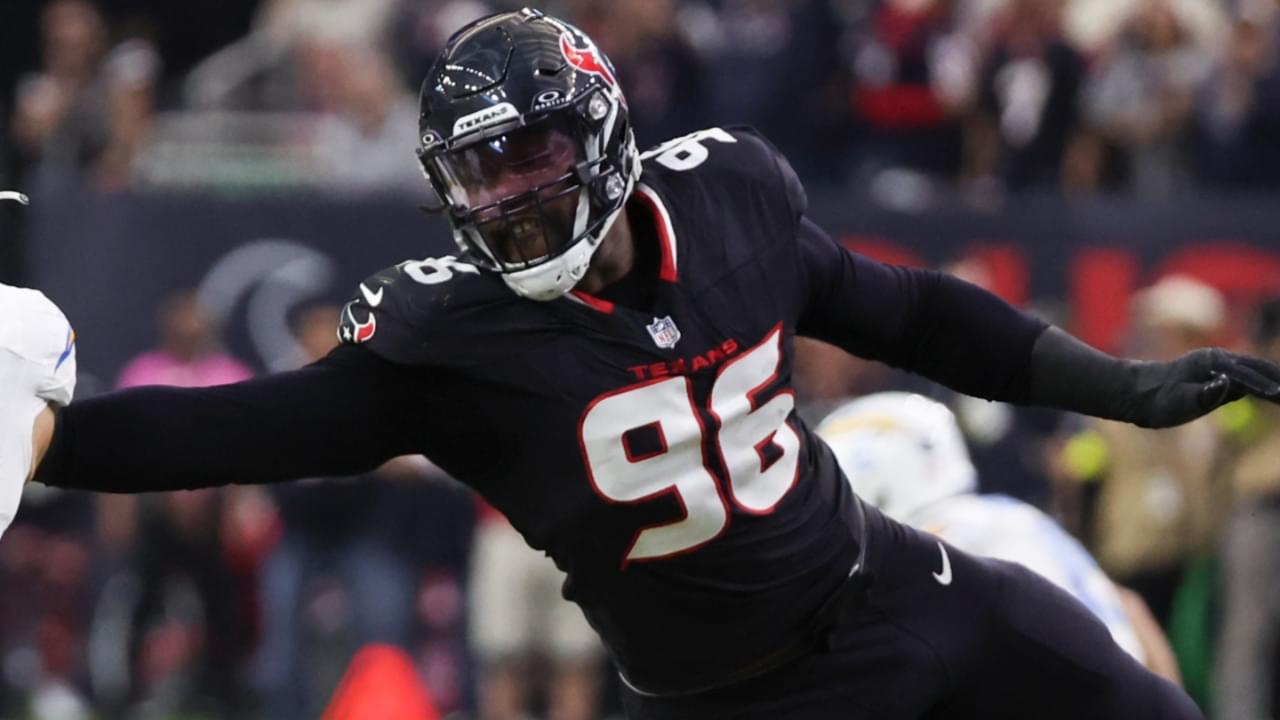 Jan 11, 2025; Houston, Texas, USA; Los Angeles Chargers quarterback Justin Herbert (10) is defended by Houston Texans defensive end Denico Autry (96) in the second quarter in an AFC wild card game at NRG Stadium.