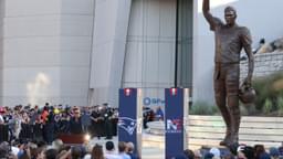 Retired New England Patriot Hall of Famer Tom Brady speaks during a statue unveiling before a game against the Washington Commanders at Gillette Stadium.