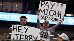 Dallas Cowboys fans hold up signs to owner Jerry Jones and defensive end Micah Parsons (11) during the second half of the game against the Baltimore Ravens at AT&T Stadium.