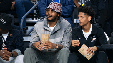 Carmelo Anthony and his son, Kiyan, watch the Don Bosco Prep Ironmen compete against the McEachern Indians in a game during the 50th annual City of Palms Classic at Suncoast Credit Union Arena in Fort Myers on Tuesday, Dec. 19, 2023