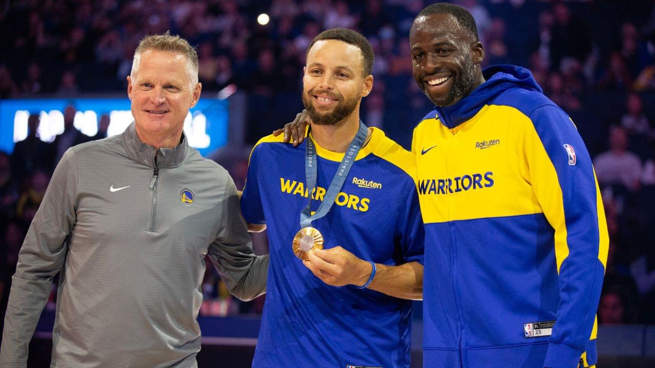 Golden State Warriors guard Stephen Curry (center) is flanked by head coach Steve Kerr and forward Draymond Green as he is presented his gold medal for his performance for Team USA at the 2024 Summer Olympics in Paris before taking on the Sacramento Kings at Chase Center.