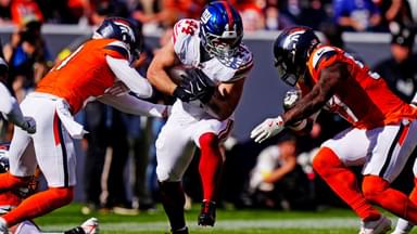 New York Giants running back Cam Skattebo (44) runs the ball against pressure from the Denver Broncos during the second half at Empower Field at Mile High.