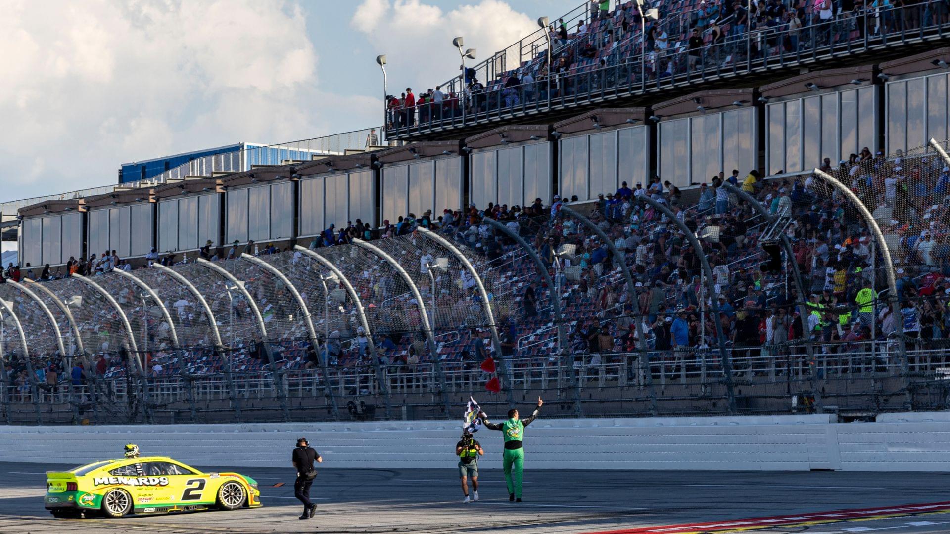Apr 27, 2025; Talladega, Alabama, USA; NASCAR Cup Series driver Austin Cindric (2) waves the checkered flag for the fans after winning the NASCAR: Jack Link's 500 at Talladega Superspeedway