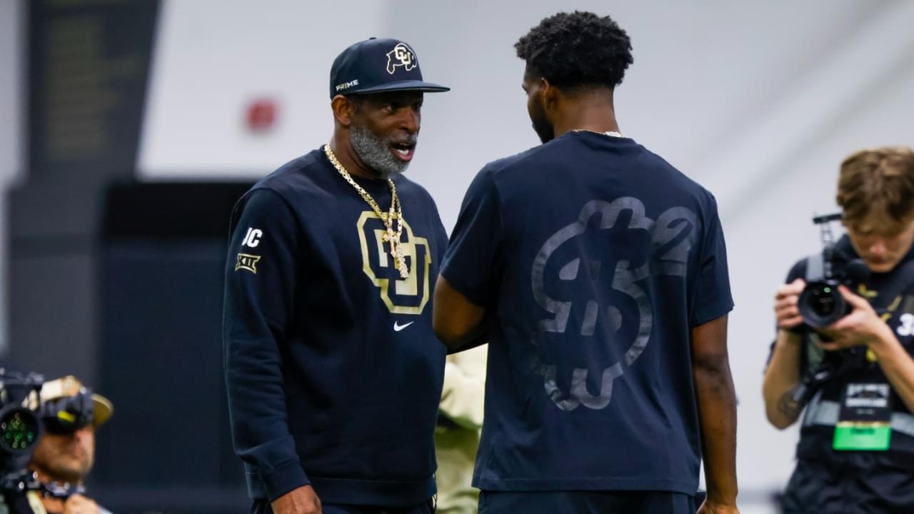 Colorado Buffaloes head coach Deion Sanders talks to his son, Colorado Buffaloes quarterback Shedeur Sanders (2), at the University of Colorado NFL Showcase at the CU Indoor Practice Facility.