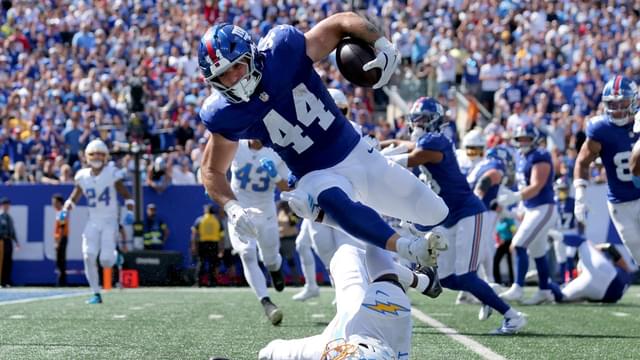 New York Giants running back Cam Skattebo (44) leaps over Los Angeles Chargers cornerback Cam Hart (20) during the second quarter at MetLife Stadium.