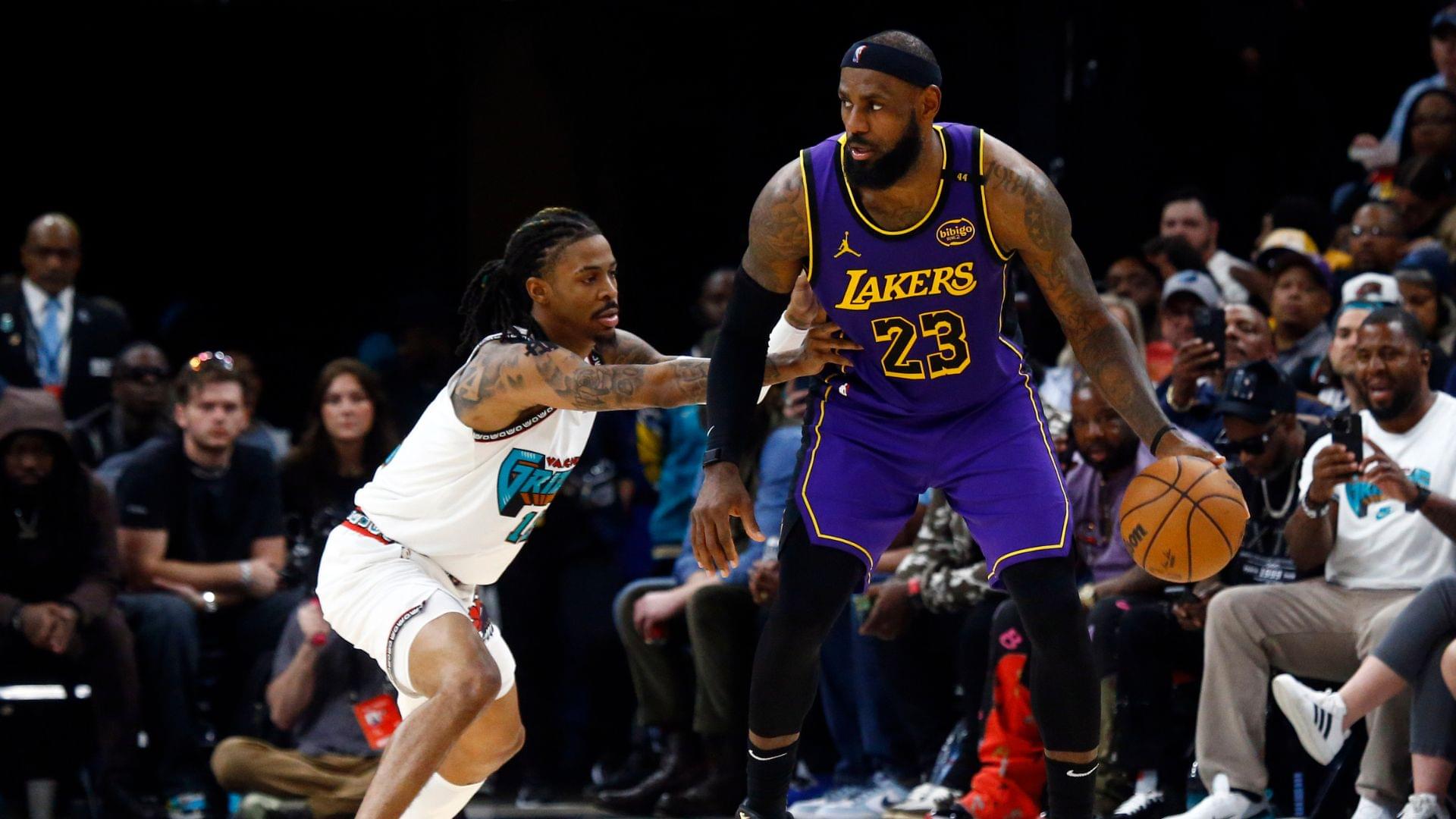 Mar 29, 2025; Memphis, Tennessee, USA; Los Angeles Lakers forward LeBron James (23) dribbles as Memphis Grizzlies guard Ja Morant (12) defends during the third quarter at FedExForum.