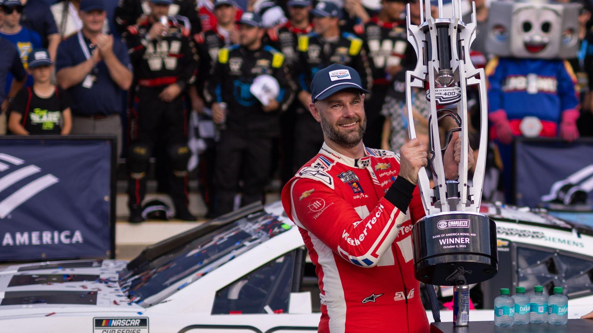 Oct 5, 2025; Concord, North Carolina, USA; NASCAR Cup Series driver Shane van Gisbergen (88) raises the Roval trophy in victory lane at Charlotte Motor Speedway Road Course.