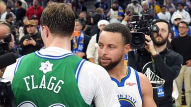 Golden State Warriors guard Stephen Curry (30) and Dallas Mavericks forward Cooper Flagg (center left) greet each other after the game at Chase Center.