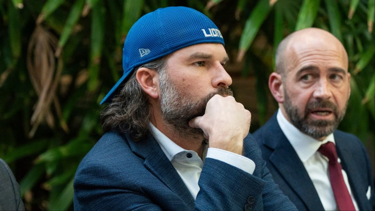 Detroit Lions fan Ryan Kennedy, center, listens during a press conference while being represented by Head Murphy Law attorney Sean Murphy, left, and Head Murphy Law founder and Managing Member Shawn Head,right, during a press conference at Head Murphy Law in Farmington Hills on Friday, December 26, 2025, while discussing the fan involved in an altercation with Pittsburgh Steelers player DK Metcalf at the Detroit Lions game at Ford Field last Sunday.