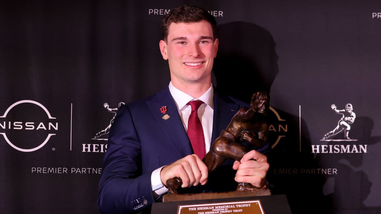 Indiana Hoosiers quarterback Fernando Mendoza poses for photos with the Heisman trophy during a press conference at the New York Marriott Marquis after winning the award.