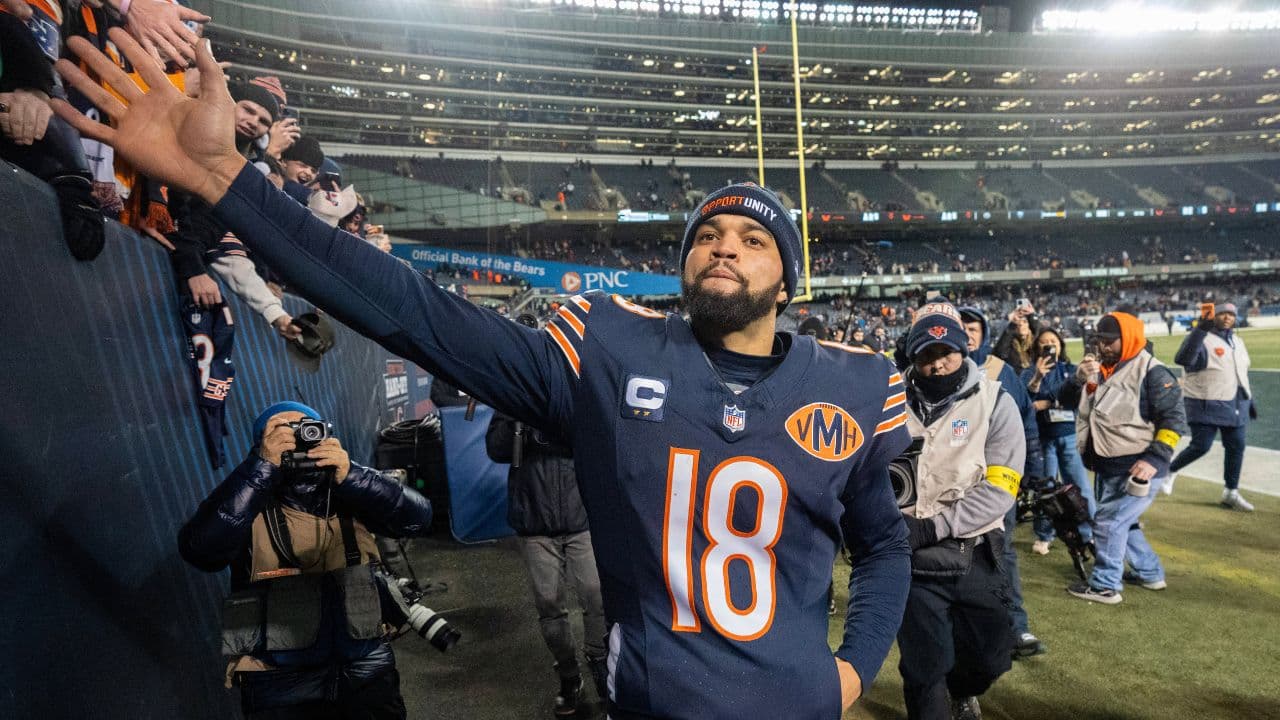 Chicago Bears quarterback Caleb Williams (18) high fives fans after defeating the Green Bay Packers during overtime at Soldier Field.