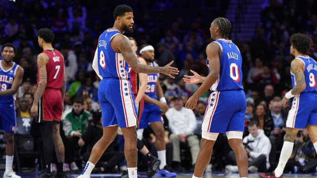 Philadelphia 76ers forward Paul George (8) reacts with guard Tyrese Maxey (0) against the Miami Heat in the first quarter at Wells Fargo Center.