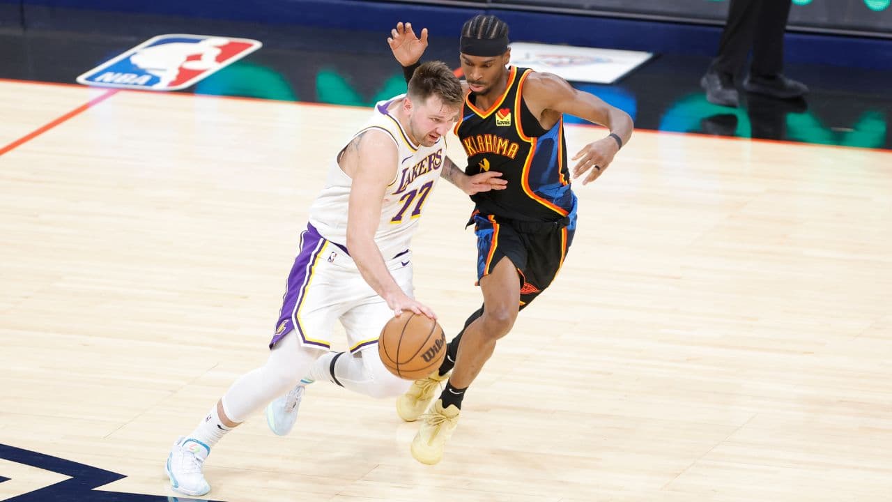 Los Angeles Lakers guard Luka Doncic (77) drives down the court beside Oklahoma City Thunder guard Shai Gilgeous-Alexander (2) during the second half at Paycom Center.
