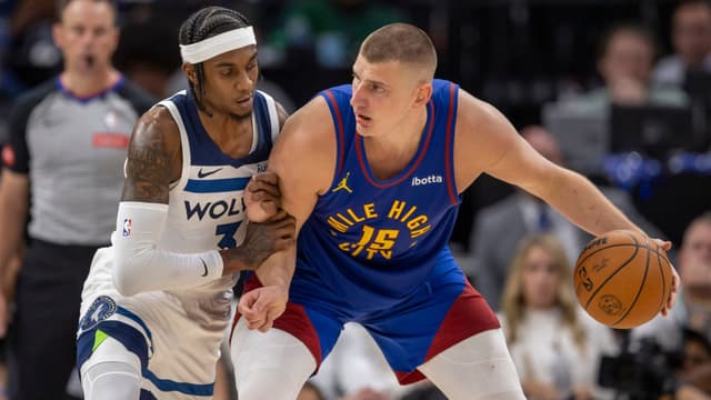 May 10, 2024; Minneapolis, Minnesota, USA; Denver Nuggets center Nikola Jokic (15) controls the ball as Minnesota Timberwolves forward Jaden McDaniels (3) defends in the second half during game three of the second round for the 2024 NBA playoffs at Target Center.