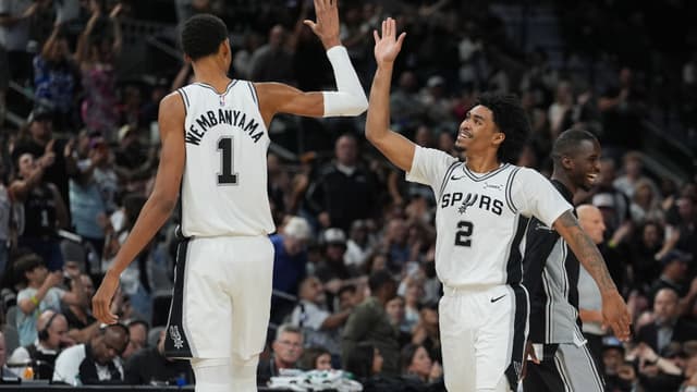 Oct 26, 2025; San Antonio, Texas, USA; San Antonio Spurs forward Victor Wembanyama (1) and guard Dylan Harper (2) celebrates in the second half against the Brooklyn Nets at Frost Bank Center.