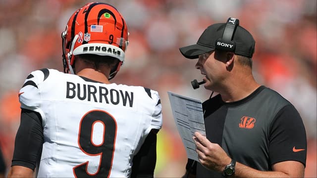 Cincinnati Bengals head coach Zac Taylor, right, has a word with quarterback Joe Burrow (9) during the first half of an NFL football game at Huntington Bank Field, Sept. 7, 2025, in Cleveland, Ohio.