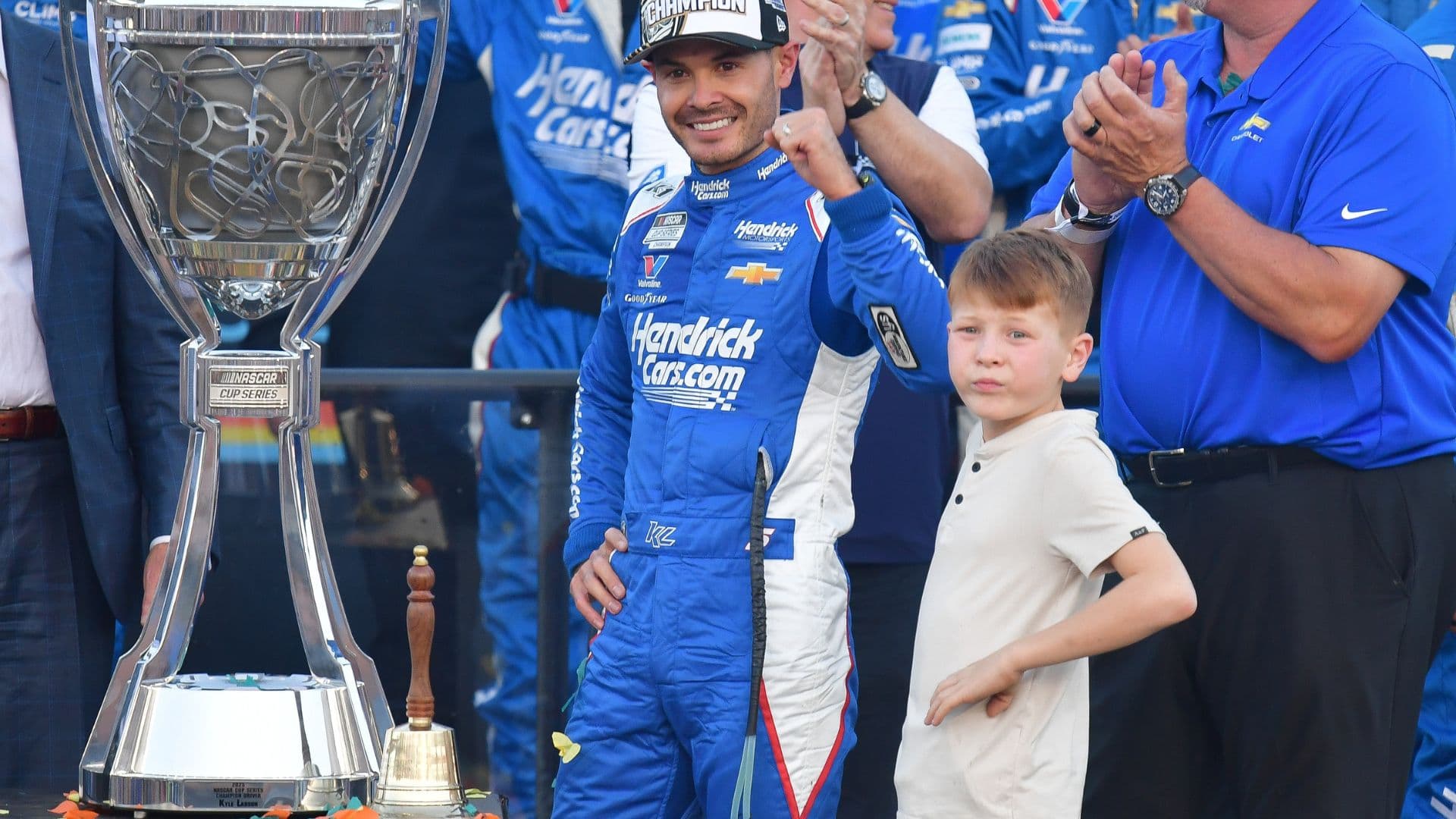 Nov 2, 2025; Avondale, Arizona, USA; NASCAR Cup Series driver Kyle Larson (5) celebrates his championship victory following the Cup Series Championship race with son Owen at Phoenix Raceway.