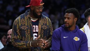 Oct 24, 2025; Los Angeles, California, USA; Los Angeles Lakers forward LeBron James (left) and son Bronny James watch from the bench in the second half against the Minnesota Timberwolves at Crypto.com Arena