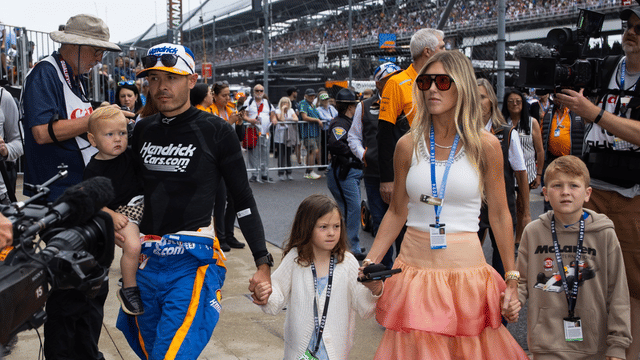 May 26, 2024; Indianapolis, Indiana, USA; Indycar Series driver Kyle Larson holds son Cooper Larson as he walks with daughter Audrey Larson, wife Katelyn Larson and son Owen Larson prior to the 108th running of the Indianapolis 500 at Indianapolis Motor Speedway. Mandatory Credit: Mark J. Rebilas-Imagn Images
