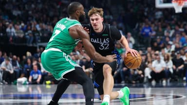 ; Dallas Mavericks forward Cooper Flagg (32) controls the ball as Boston Celtics guard Jaylen Brown (7) defends during the first quarter at American Airlines Center
