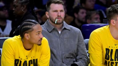 Feb 12, 2026; Los Angeles, California, USA; Los Angeles Lakers guard Luka Doncic (77) looks on from the bench as he chews on a dental flosser in the second half against the Dallas Mavericks at Crypto.com Arena.